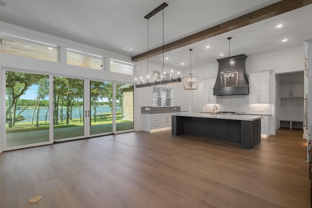 kitchen featuring premium range hood, white cabinetry, and a healthy amount of sunlight