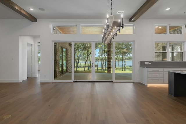 interior space featuring beam ceiling, a chandelier, high vaulted ceiling, and dark wood-type flooring