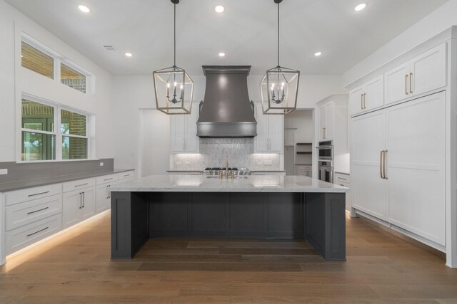 kitchen featuring white cabinetry, decorative light fixtures, dark hardwood / wood-style floors, and custom exhaust hood