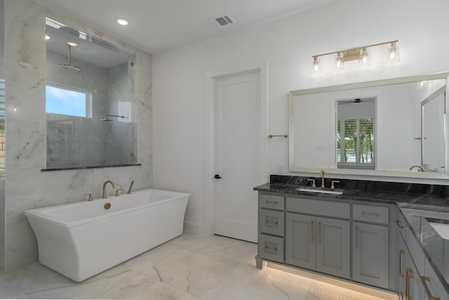 bathroom featuring shower with separate bathtub and vanity