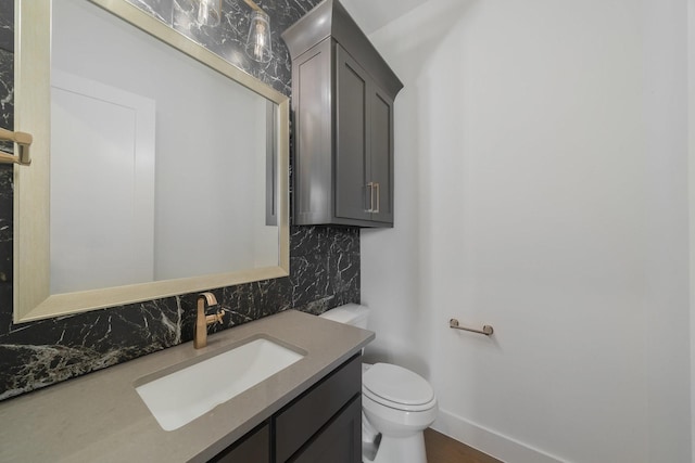 bathroom with hardwood / wood-style flooring, vanity, toilet, and backsplash