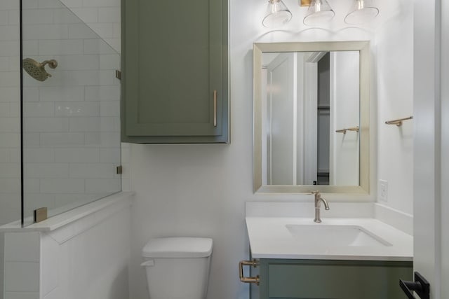 bathroom featuring tiled shower, vanity, and toilet