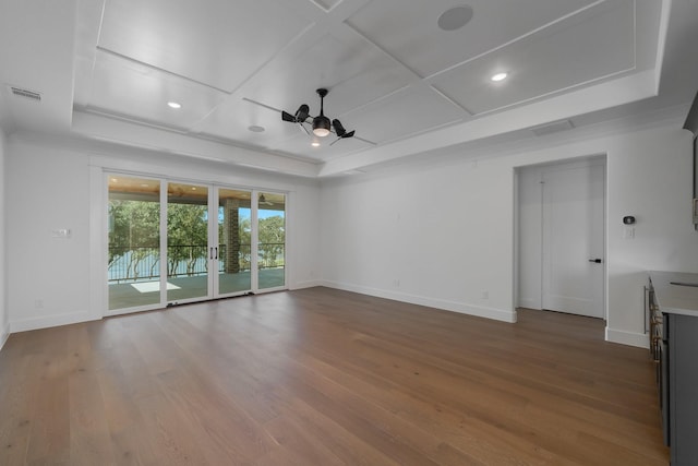 empty room featuring a tray ceiling, ceiling fan, coffered ceiling, and hardwood / wood-style flooring