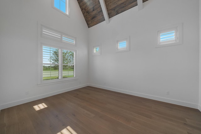 empty room featuring beamed ceiling, wood ceiling, dark wood-type flooring, and high vaulted ceiling