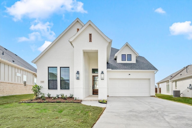 view of front of home with cooling unit, a garage, and a front yard