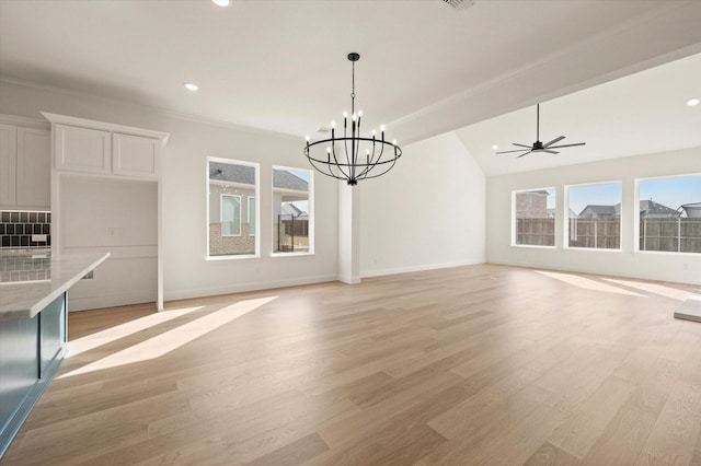 unfurnished living room with ceiling fan with notable chandelier, lofted ceiling, crown molding, and light hardwood / wood-style flooring