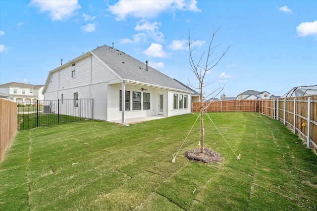 back of house with ceiling fan, a yard, and a patio