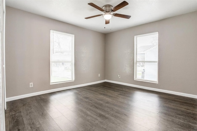 empty room featuring ceiling fan, dark wood-type flooring, and a healthy amount of sunlight