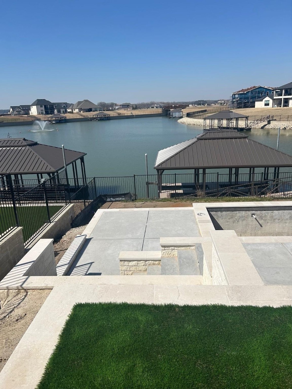 exterior space with a water view, fence, and a gazebo