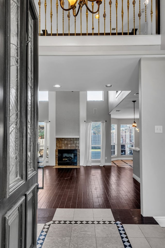 interior space featuring a tile fireplace, a high ceiling, and dark tile patterned flooring