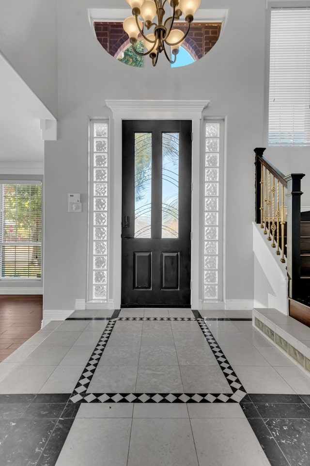 entryway with a chandelier and dark tile patterned floors