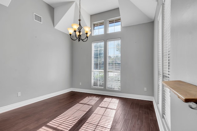 empty room featuring hardwood / wood-style flooring and a chandelier