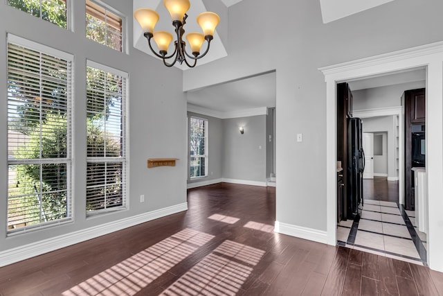 unfurnished dining area with dark wood-type flooring and a chandelier