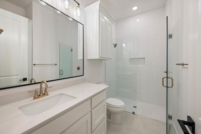 bathroom with tile patterned flooring, a shower with door, vanity, and toilet