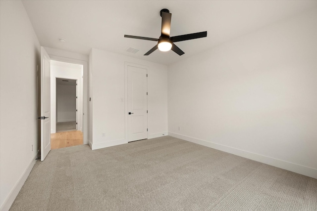 unfurnished bedroom with ceiling fan, light colored carpet, and a closet