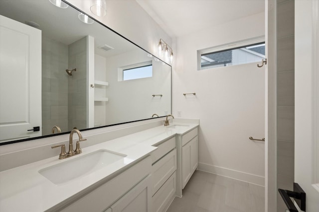 bathroom with tile patterned flooring, vanity, and walk in shower