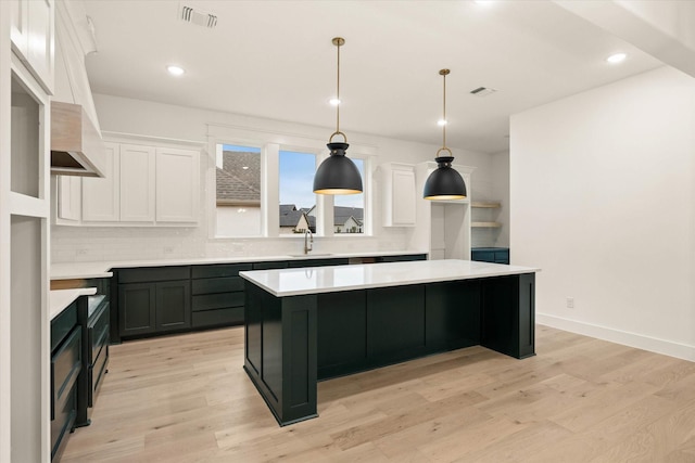 kitchen featuring light hardwood / wood-style flooring, white cabinetry, and a kitchen island