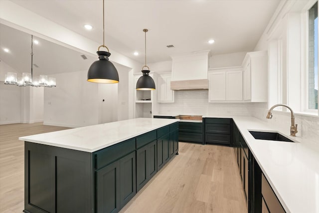 kitchen featuring white cabinetry, a center island, sink, backsplash, and custom exhaust hood