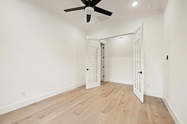 empty room with ceiling fan, light hardwood / wood-style floors, ornamental molding, and french doors