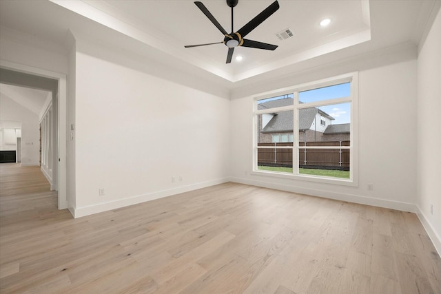 unfurnished room with ornamental molding, a tray ceiling, ceiling fan, and light hardwood / wood-style floors