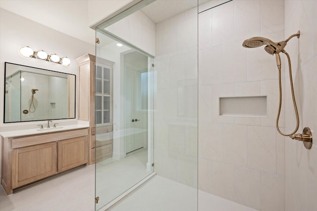 bathroom with tiled shower and vanity