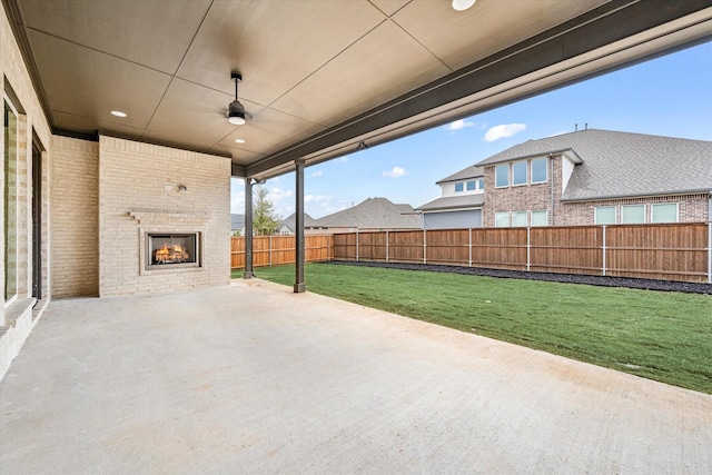 view of patio featuring an outdoor brick fireplace and ceiling fan