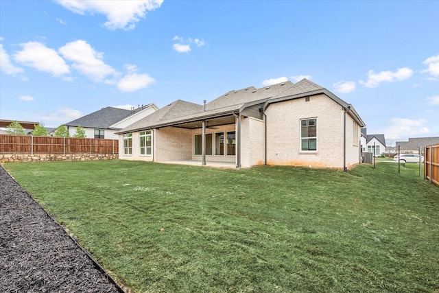 rear view of property with a yard and a patio area