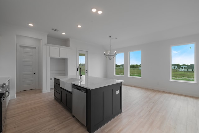 kitchen with stainless steel appliances, a wealth of natural light, a center island with sink, and light hardwood / wood-style floors