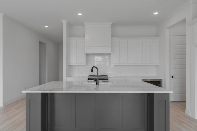 kitchen with light stone countertops, white cabinets, and a spacious island