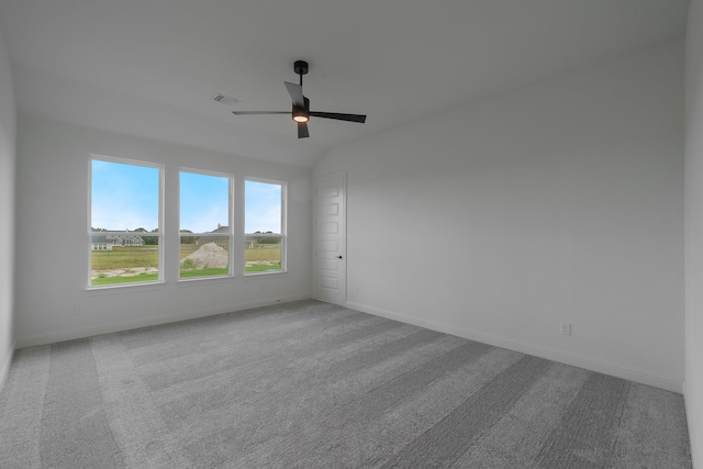 carpeted empty room with vaulted ceiling and ceiling fan