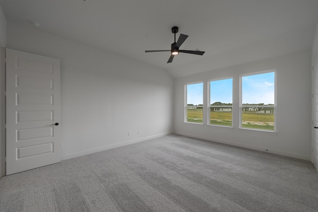 carpeted empty room featuring ceiling fan and lofted ceiling