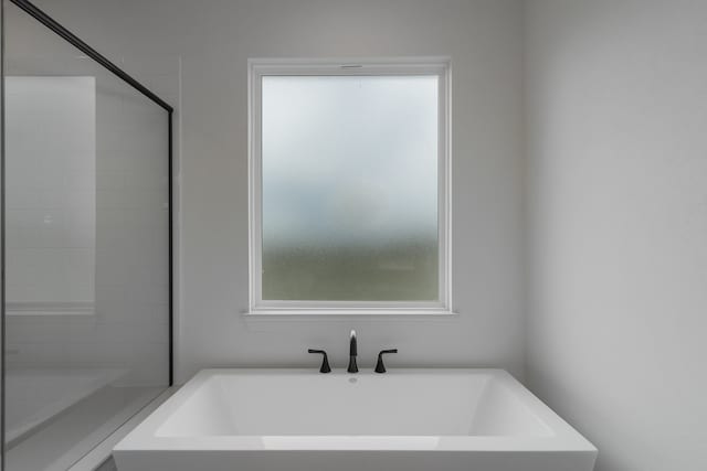 bathroom with a tub to relax in