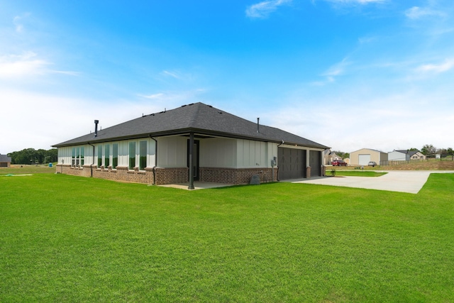 rear view of house featuring a garage and a lawn