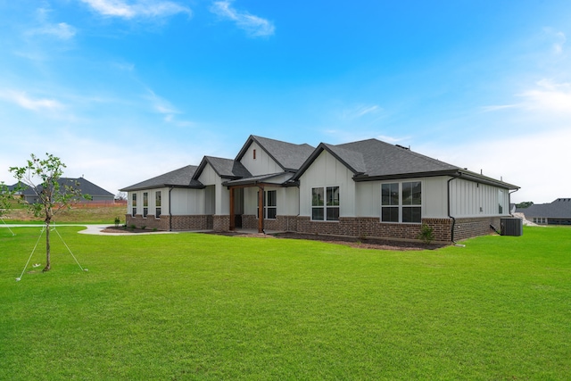 view of front of property with cooling unit and a front yard