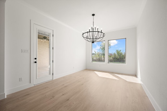 unfurnished dining area with light hardwood / wood-style floors and a notable chandelier