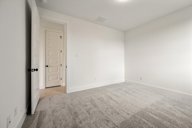 spare room featuring light carpet