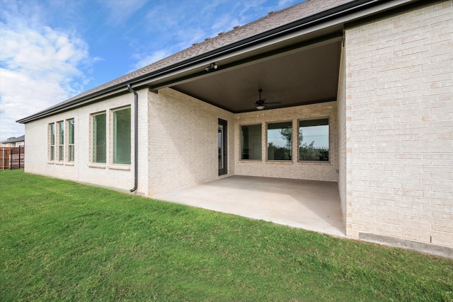 rear view of house with a patio, ceiling fan, and a lawn