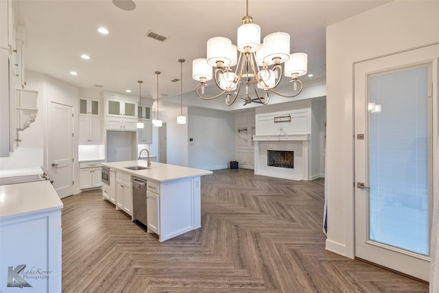 kitchen featuring a kitchen island with sink, decorative light fixtures, dark parquet floors, and white cabinets