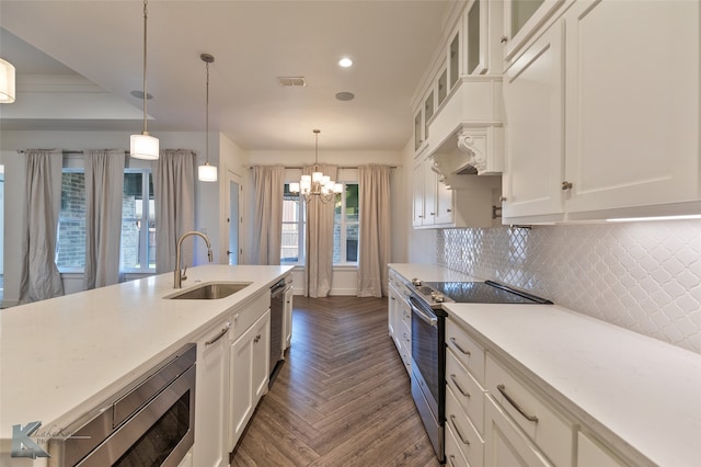 kitchen with pendant lighting, sink, appliances with stainless steel finishes, white cabinetry, and dark parquet floors