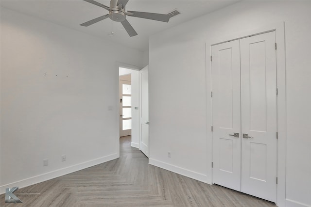 unfurnished bedroom with ceiling fan, a closet, and light parquet floors