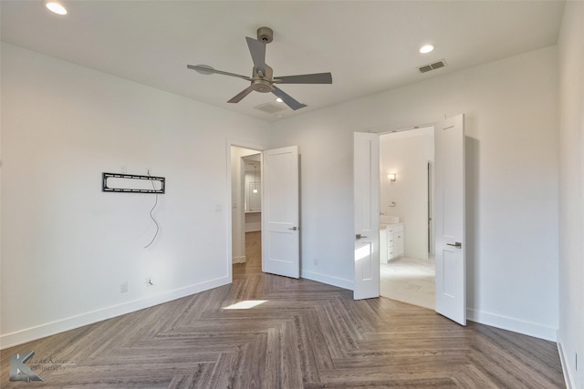 unfurnished bedroom with ceiling fan, parquet flooring, and ensuite bath