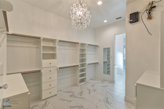 spacious closet featuring an inviting chandelier