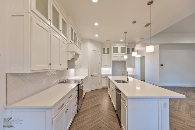 kitchen featuring stainless steel appliances, sink, a center island with sink, and white cabinets