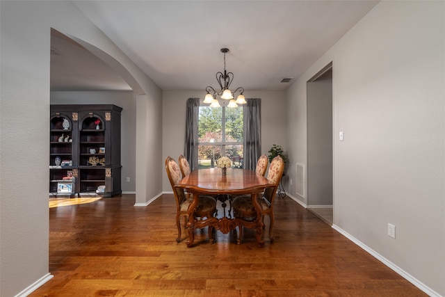 dining room with hardwood / wood-style flooring and a chandelier