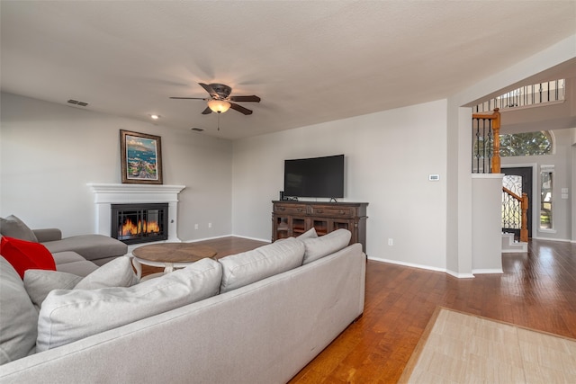 living room with wood-type flooring, a textured ceiling, and ceiling fan