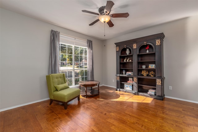 living area featuring hardwood / wood-style floors and ceiling fan