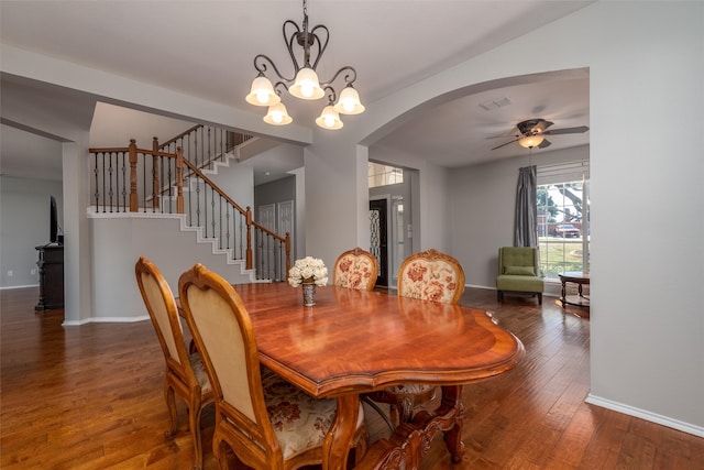 dining area featuring dark wood-type flooring and ceiling fan with notable chandelier