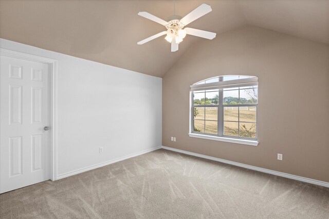 spare room featuring light colored carpet, ceiling fan, and lofted ceiling