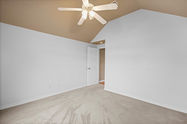 carpeted spare room featuring ceiling fan and vaulted ceiling