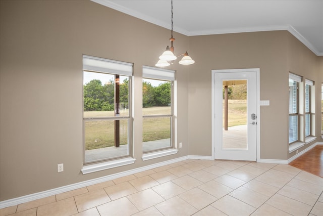 unfurnished dining area featuring light tile patterned floors, ornamental molding, a wealth of natural light, and a chandelier